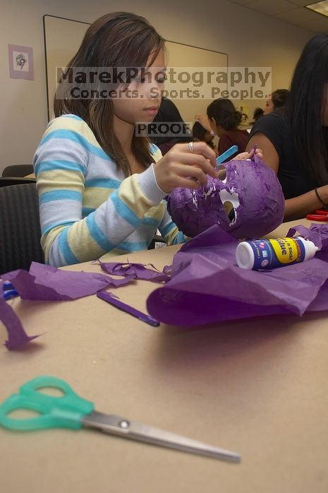 Mae Cortes decorates her mask at a domestic violence expressive arts workshop for survivors and friends of survivors of domestic and relationship violence.

Filename: SRM_20061023_1736187.jpg
Aperture: f/5.6
Shutter Speed: 1/100
Body: Canon EOS 20D
Lens: Canon EF-S 18-55mm f/3.5-5.6