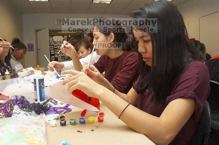 Emily Ng, right, decorates her mask next to Vivian Mai-Tran, left, at a domestic violence expressive arts workshop for survivors and friends of survivors of domestic and relationship violence.

Filename: SRM_20061023_1738546.jpg
Aperture: f/5.6
Shutter Speed: 1/100
Body: Canon EOS 20D
Lens: Canon EF-S 18-55mm f/3.5-5.6