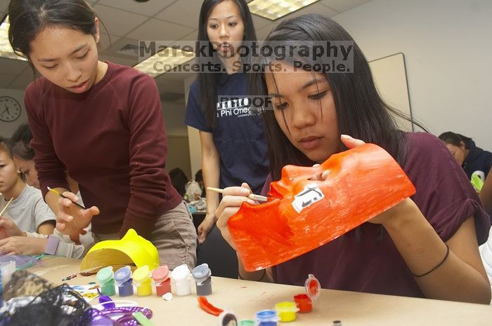 Emily Ng, right, decorates her mask next to Vivian Mai-Tran, left, at a domestic violence expressive arts workshop for survivors and friends of survivors of domestic and relationship violence.

Filename: SRM_20061023_1739087.jpg
Aperture: f/5.6
Shutter Speed: 1/100
Body: Canon EOS 20D
Lens: Canon EF-S 18-55mm f/3.5-5.6