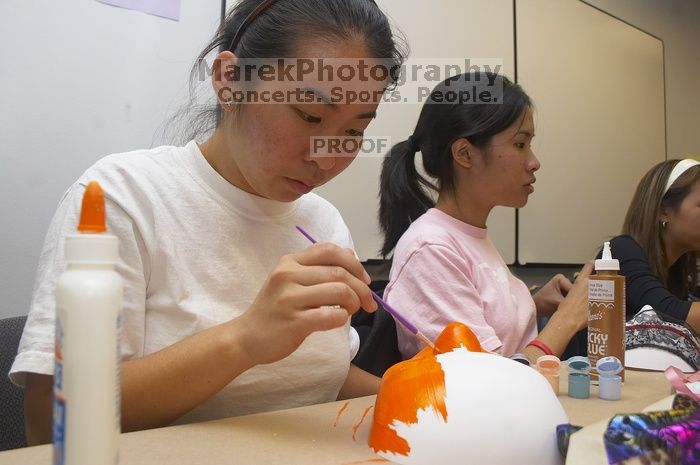 Hannah Yee, with Diane Nguyen, painting their masks at a domestic violence expressive arts workshop for survivors and friends of survivors of domestic and relationship violence.

Filename: SRM_20061023_1741163.jpg
Aperture: f/5.6
Shutter Speed: 1/100
Body: Canon EOS 20D
Lens: Canon EF-S 18-55mm f/3.5-5.6