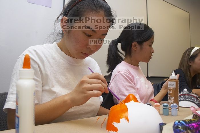 Hannah Yee, with Diane Nguyen, painting their masks at a domestic violence expressive arts workshop for survivors and friends of survivors of domestic and relationship violence.

Filename: SRM_20061023_1741184.jpg
Aperture: f/5.6
Shutter Speed: 1/100
Body: Canon EOS 20D
Lens: Canon EF-S 18-55mm f/3.5-5.6