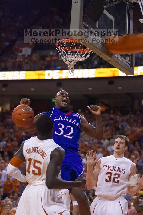 KU senior Darnell Jackson (#32, Forward) dunks over UT freshman Alexis Wangmene (#15, F/C) and UT junior Connor Atchley (#32, F/C).  The University of Texas (UT) Longhorns defeated the University of Kansas Jayhawks 72-69 in Austin, Texas on Monday, February 11, 2008.

Filename: SRM_20080211_2046144.jpg
Aperture: f/2.8
Shutter Speed: 1/640
Body: Canon EOS-1D Mark II
Lens: Canon EF 80-200mm f/2.8 L