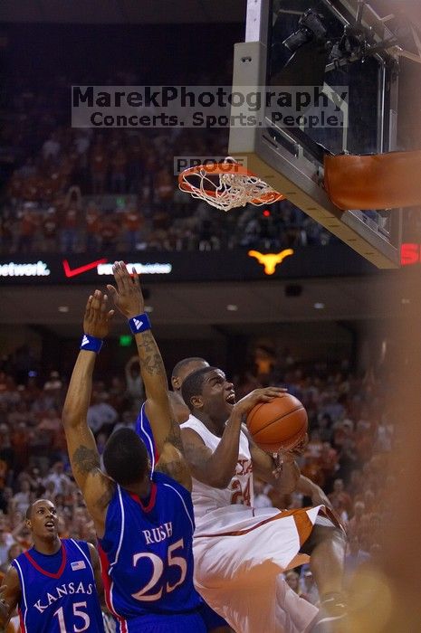 UT sophomore Justin Mason (#24, G) attempts a shot over KU junior Brandon Rush (#25, Guard) and KU junior Mario Chalmers (#15, Guard).  The University of Texas (UT) Longhorns defeated the University of Kansas Jayhawks 72-69 in Austin, Texas on Monday, February 11, 2008.

Filename: SRM_20080211_2128264.jpg
Aperture: f/2.8
Shutter Speed: 1/640
Body: Canon EOS-1D Mark II
Lens: Canon EF 80-200mm f/2.8 L