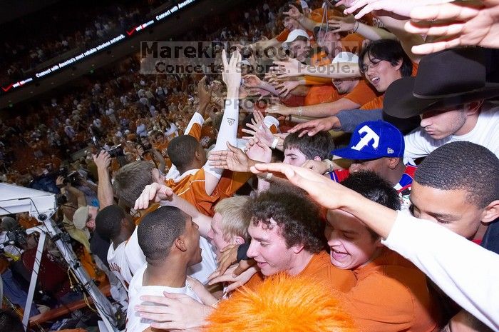 The fans react to the Longhorns' win, rubbing the head of UT freshman Gary Johnson (#1, F) and shaking hands with other players.  The University of Texas (UT) Longhorns defeated the University of Kansas Jayhawks 72-69 in Austin, Texas on Monday, February 11, 2008.

Filename: SRM_20080211_2219082.jpg
Aperture: f/5.6
Shutter Speed: 1/250
Body: Canon EOS-1D Mark II
Lens: Canon EF 16-35mm f/2.8 L