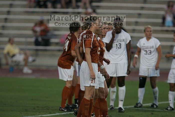 UT senior Kasey Moore (#14, Defender), UT senior Jill Gilbeau (#4, Defender and Midfielder), and UT junior Emily Anderson (#21, Forward) form a wall in front of a free kick.  The University of Texas women's soccer team tied 0-0 against the Texas A&M Aggies Friday night, September 27, 2008.

Filename: SRM_20080926_1918043.jpg
Aperture: f/4.0
Shutter Speed: 1/800
Body: Canon EOS-1D Mark II
Lens: Canon EF 300mm f/2.8 L IS