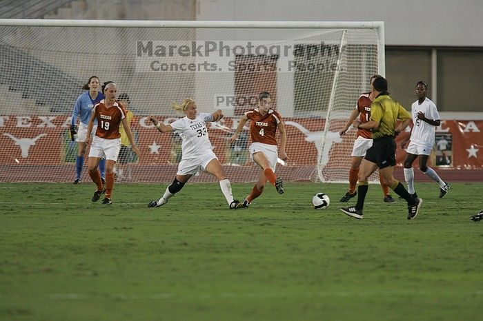 UT sophomore Erica Campanelli (#19, Defender) and UT senior Jill Gilbeau (#4, Defender and Midfielder) defend as UT senior Dianna Pfenninger (#8, Goalkeeper) watches.  The University of Texas women's soccer team tied 0-0 against the Texas A&M Aggies Friday night, September 27, 2008.

Filename: SRM_20080926_1924027.jpg
Aperture: f/4.0
Shutter Speed: 1/500
Body: Canon EOS-1D Mark II
Lens: Canon EF 300mm f/2.8 L IS