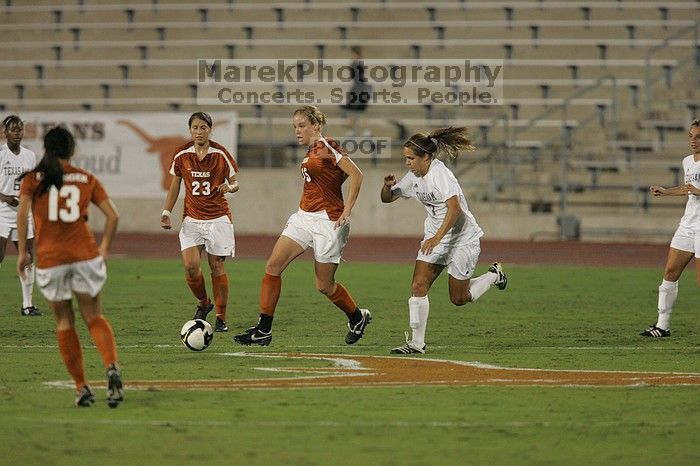 UT freshman Kylie Doniak (#15, Midfielder) has the ball as UT senior Courtney Gaines (#23, Midfielder) and UT freshman Amanda Lisberger (#13, Midfielder) watch.  The University of Texas women's soccer team tied 0-0 against the Texas A&M Aggies Friday night, September 27, 2008.

Filename: SRM_20080926_1937001.jpg
Aperture: f/4.0
Shutter Speed: 1/400
Body: Canon EOS-1D Mark II
Lens: Canon EF 300mm f/2.8 L IS