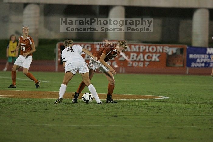 UT freshman Kylie Doniak (#15, Midfielder) tackles the ball as UT sophomore Erica Campanelli (#19, Defender) watches.  The University of Texas women's soccer team tied 0-0 against the Texas A&M Aggies Friday night, September 27, 2008.

Filename: SRM_20080926_1942040.jpg
Aperture: f/4.0
Shutter Speed: 1/500
Body: Canon EOS-1D Mark II
Lens: Canon EF 300mm f/2.8 L IS