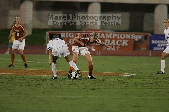 UT freshman Kylie Doniak (#15, Midfielder) tackles the ball as UT sophomore Erica Campanelli (#19, Defender) watches.  The University of Texas women's soccer team tied 0-0 against the Texas A&M Aggies Friday night, September 27, 2008.

Filename: SRM_20080926_1942042.jpg
Aperture: f/4.0
Shutter Speed: 1/500
Body: Canon EOS-1D Mark II
Lens: Canon EF 300mm f/2.8 L IS