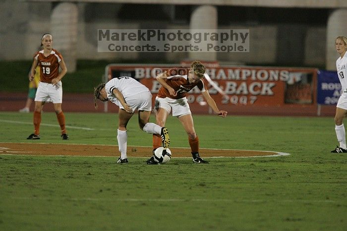 UT freshman Kylie Doniak (#15, Midfielder) tackles the ball as UT sophomore Erica Campanelli (#19, Defender) watches.  The University of Texas women's soccer team tied 0-0 against the Texas A&M Aggies Friday night, September 27, 2008.

Filename: SRM_20080926_1942043.jpg
Aperture: f/4.0
Shutter Speed: 1/500
Body: Canon EOS-1D Mark II
Lens: Canon EF 300mm f/2.8 L IS