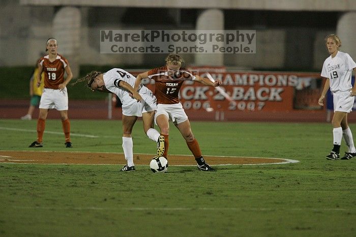 UT freshman Kylie Doniak (#15, Midfielder) tackles the ball as UT sophomore Erica Campanelli (#19, Defender) watches.  The University of Texas women's soccer team tied 0-0 against the Texas A&M Aggies Friday night, September 27, 2008.

Filename: SRM_20080926_1942064.jpg
Aperture: f/4.0
Shutter Speed: 1/500
Body: Canon EOS-1D Mark II
Lens: Canon EF 300mm f/2.8 L IS