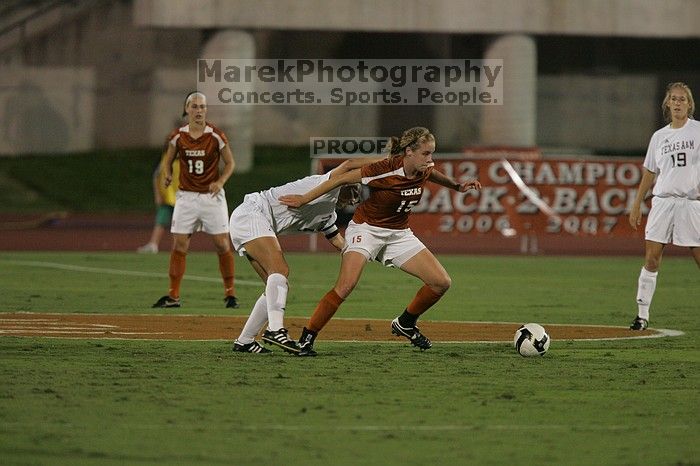 UT freshman Kylie Doniak (#15, Midfielder) tackles the ball as UT sophomore Erica Campanelli (#19, Defender) watches.  The University of Texas women's soccer team tied 0-0 against the Texas A&M Aggies Friday night, September 27, 2008.

Filename: SRM_20080926_1942080.jpg
Aperture: f/4.0
Shutter Speed: 1/500
Body: Canon EOS-1D Mark II
Lens: Canon EF 300mm f/2.8 L IS