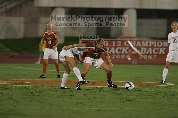 UT freshman Kylie Doniak (#15, Midfielder) tackles the ball as UT sophomore Erica Campanelli (#19, Defender) watches.  The University of Texas women's soccer team tied 0-0 against the Texas A&M Aggies Friday night, September 27, 2008.

Filename: SRM_20080926_1942089.jpg
Aperture: f/4.0
Shutter Speed: 1/500
Body: Canon EOS-1D Mark II
Lens: Canon EF 300mm f/2.8 L IS