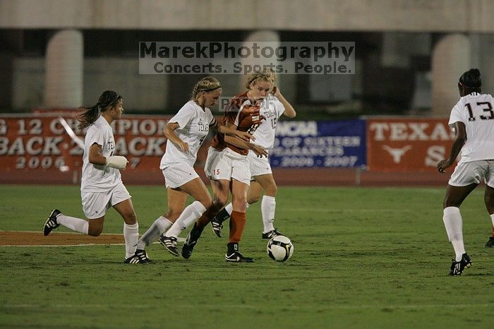 UT freshman Kylie Doniak (#15, Midfielder) tackles the ball as UT sophomore Erica Campanelli (#19, Defender) watches.  The University of Texas women's soccer team tied 0-0 against the Texas A&M Aggies Friday night, September 27, 2008.

Filename: SRM_20080926_1942105.jpg
Aperture: f/4.0
Shutter Speed: 1/500
Body: Canon EOS-1D Mark II
Lens: Canon EF 300mm f/2.8 L IS