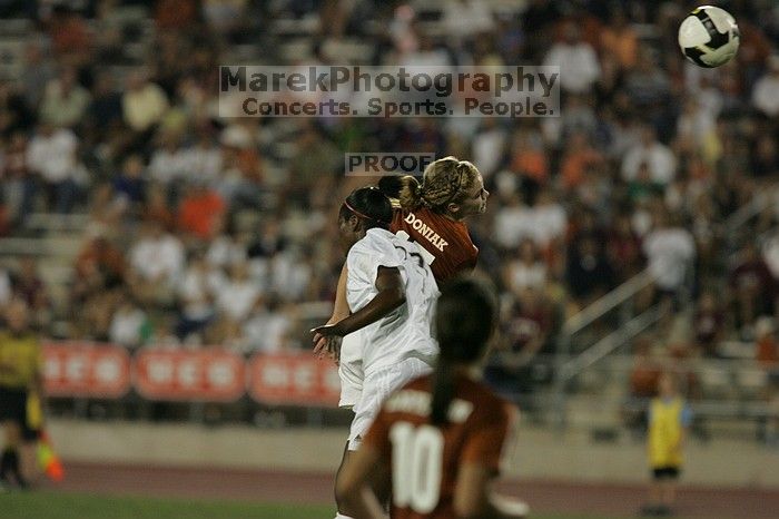 UT freshman Kylie Doniak (#15, Midfielder) headed the ball as UT senior Stephanie Logterman (#10, Defender) watches.  The University of Texas women's soccer team tied 0-0 against the Texas A&M Aggies Friday night, September 27, 2008.

Filename: SRM_20080926_1945108.jpg
Aperture: f/4.0
Shutter Speed: 1/500
Body: Canon EOS-1D Mark II
Lens: Canon EF 300mm f/2.8 L IS