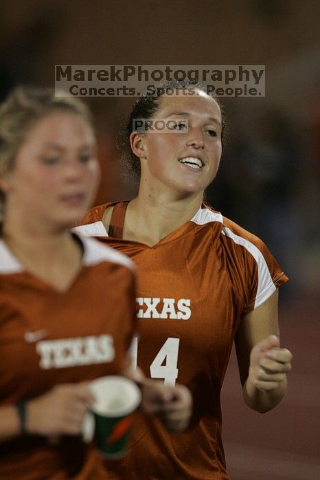 UT senior Kasey Moore (#14, Defender) running back to the team benches before the second half.  The University of Texas women's soccer team tied 0-0 against the Texas A&M Aggies Friday night, September 27, 2008.

Filename: SRM_20080926_2000526.jpg
Aperture: f/2.8
Shutter Speed: 1/500
Body: Canon EOS-1D Mark II
Lens: Canon EF 300mm f/2.8 L IS