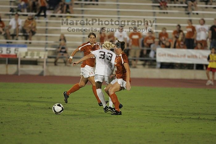 UT senior Kasey Moore (#14, Defender) tackles the ball as UT senior Courtney Gaines (#23, Midfielder) watches.  The University of Texas women's soccer team tied 0-0 against the Texas A&M Aggies Friday night, September 27, 2008.

Filename: SRM_20080926_2012065.jpg
Aperture: f/2.8
Shutter Speed: 1/500
Body: Canon EOS-1D Mark II
Lens: Canon EF 300mm f/2.8 L IS