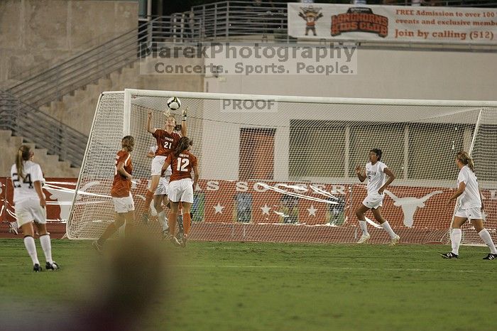 UT junior Emily Anderson (#21, Forward) takes a header shot on goal as UT sophomore Alisha Ortiz (#12, Forward) and UT freshman Kylie Doniak (#15, Midfielder) watch.  The University of Texas women's soccer team tied 0-0 against the Texas A&M Aggies Friday night, September 27, 2008.

Filename: SRM_20080926_2013101.jpg
Aperture: f/2.8
Shutter Speed: 1/500
Body: Canon EOS-1D Mark II
Lens: Canon EF 300mm f/2.8 L IS