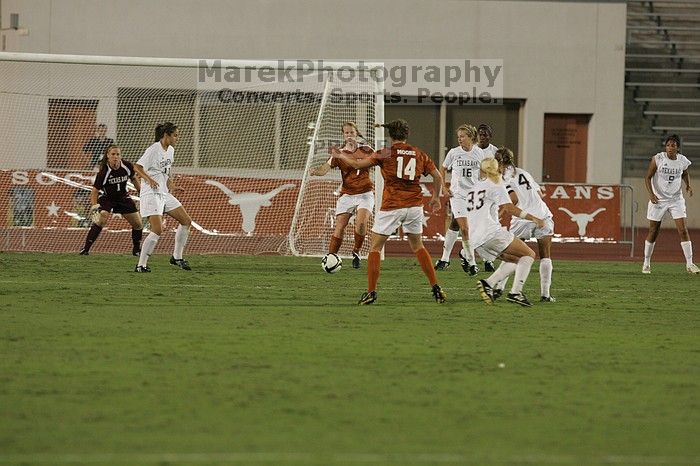 UT freshman Courtney Goodson (#7, Forward and Midfielder) drops the ball back to UT senior Kasey Moore (#14, Defender) for a shot on goal.  The University of Texas women's soccer team tied 0-0 against the Texas A&M Aggies Friday night, September 27, 2008.

Filename: SRM_20080926_2016343.jpg
Aperture: f/4.0
Shutter Speed: 1/400
Body: Canon EOS-1D Mark II
Lens: Canon EF 300mm f/2.8 L IS