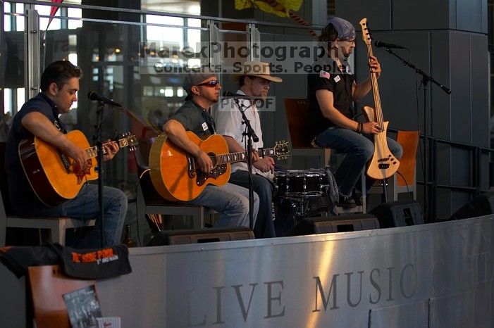 The Gene Pool, performing at the Austin airport.  Geno Stroia II on vocals/guitar, Jorge Castillo on vocals/guitar, Travis Woodard on drums and Steven Ray Will on vocals/bass guitar.

Filename: SRM_20060518_160104_1.jpg
Aperture: f/3.2
Shutter Speed: 1/250
Body: Canon EOS 20D
Lens: Canon EF 80-200mm f/2.8 L