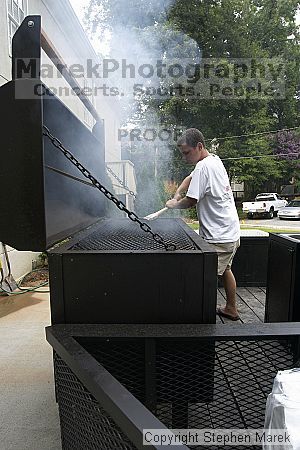 Frank Haren cleans his grill after Coach Paul Hewitt cooked out at AXO Thursday night.  AXO was the winning sorority for the basketball attendance competition.

Filename: crw_0057_std.jpg
Aperture: f/6.3
Shutter Speed: 1/80
Body: Canon EOS DIGITAL REBEL
Lens: Sigma 15-30mm f/3.5-4.5 EX Aspherical DG DF