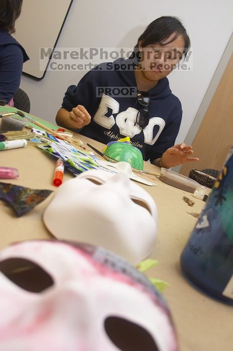 Stephanie Luu, with Hannah Jones' mask in the foreground.  Domestic violence expressive arts workshop for survivors and friends of survivors of domestic and relationship violence.

Filename: SRM_20061023_1800148.jpg
Aperture: f/5.6
Shutter Speed: 1/100
Body: Canon EOS 20D
Lens: Canon EF-S 18-55mm f/3.5-5.6