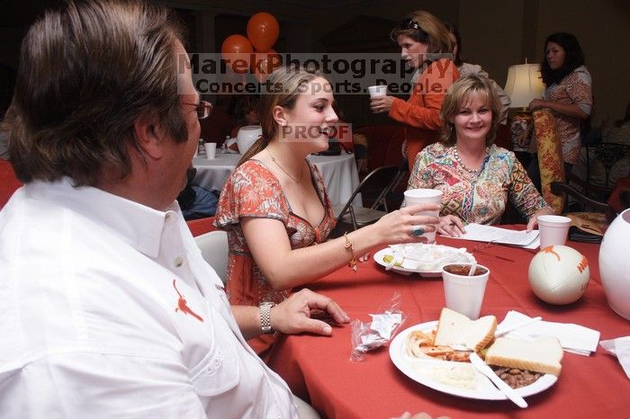 Haley Lyons and her parents sign the Kappa house leasing contract.  Kappa Kappa Gamma (KKG) hosted a parents' weekend barbecue before the UT vs Nebraska football game on Saturday, October 27, 2007 at their sorority house.

Filename: SRM_20071027_1205505.jpg
Aperture: f/8.0
Shutter Speed: 1/250
Body: Canon EOS 20D
Lens: Canon EF-S 18-55mm f/3.5-5.6