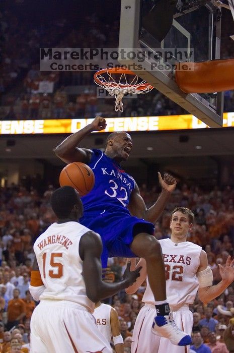 KU senior Darnell Jackson (#32, Forward) dunks over UT freshman Alexis Wangmene (#15, F/C) and UT junior Connor Atchley (#32, F/C).  The University of Texas (UT) Longhorns defeated the University of Kansas Jayhawks 72-69 in Austin, Texas on Monday, February 11, 2008.

Filename: SRM_20080211_2046123.jpg
Aperture: f/2.8
Shutter Speed: 1/640
Body: Canon EOS-1D Mark II
Lens: Canon EF 80-200mm f/2.8 L