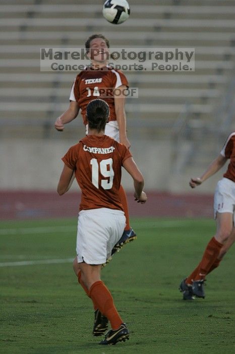 UT senior Kasey Moore (#14, Defender) heads the ball to UT sophomore Erica Campanelli (#19, Defender).  The University of Texas women's soccer team tied 0-0 against the Texas A&M Aggies Friday night, September 27, 2008.

Filename: SRM_20080926_1913222.jpg
Aperture: f/4.0
Shutter Speed: 1/800
Body: Canon EOS-1D Mark II
Lens: Canon EF 300mm f/2.8 L IS