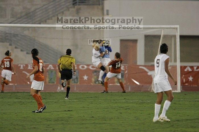 UT freshman Amanda Lisberger (#13, Midfielder) and UT senior Kasey Moore (#14, Defender) watch as UT senior Dianna Pfenninger (#8, Goalkeeper) catches a shot on goal.  The University of Texas women's soccer team tied 0-0 against the Texas A&M Aggies Friday night, September 27, 2008.

Filename: SRM_20080926_1928581.jpg
Aperture: f/4.0
Shutter Speed: 1/500
Body: Canon EOS-1D Mark II
Lens: Canon EF 300mm f/2.8 L IS