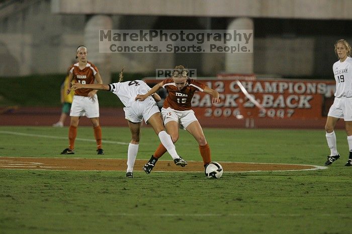 UT freshman Kylie Doniak (#15, Midfielder) tackles the ball as UT sophomore Erica Campanelli (#19, Defender) watches.  The University of Texas women's soccer team tied 0-0 against the Texas A&M Aggies Friday night, September 27, 2008.

Filename: SRM_20080926_1942067.jpg
Aperture: f/4.0
Shutter Speed: 1/500
Body: Canon EOS-1D Mark II
Lens: Canon EF 300mm f/2.8 L IS