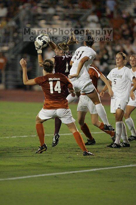 A shot on goal is caught as UT senior Kasey Moore (#14, Defender) and UT junior Emily Anderson (#21, Forward) hope for some action.  The University of Texas women's soccer team tied 0-0 against the Texas A&M Aggies Friday night, September 27, 2008.

Filename: SRM_20080926_2045587.jpg
Aperture: f/2.8
Shutter Speed: 1/500
Body: Canon EOS-1D Mark II
Lens: Canon EF 300mm f/2.8 L IS