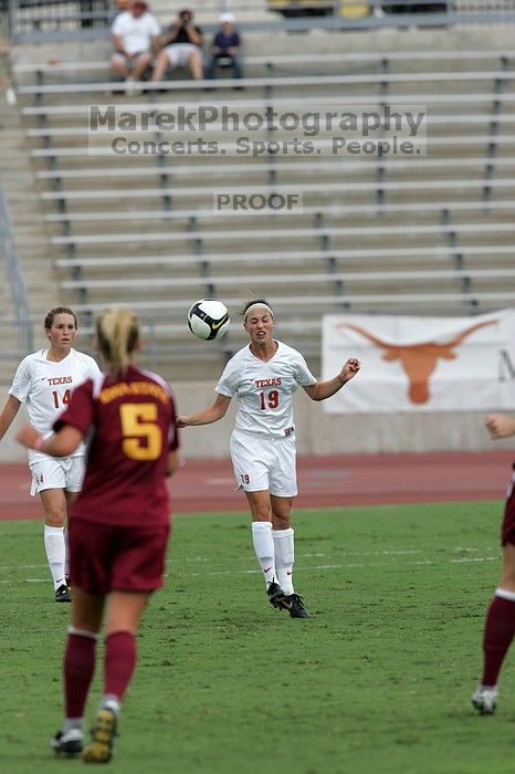 UT sophomore Erica Campanelli (#19, Defender) heads the ball as UT senior Kasey Moore (#14, Defender) watches in the second half.  The University of Texas women's soccer team won 2-1 against the Iowa State Cyclones Sunday afternoon, October 5, 2008.

Filename: SRM_20081005_13182204.jpg
Aperture: f/5.6
Shutter Speed: 1/1600
Body: Canon EOS-1D Mark II
Lens: Canon EF 300mm f/2.8 L IS